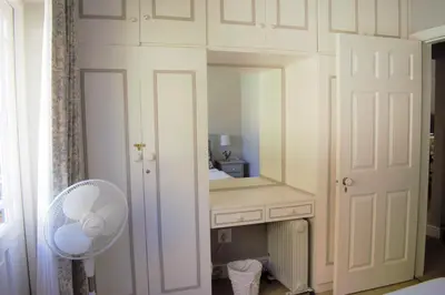 a dressing room with a mirror and a fan at Mafunyani Cottage in Franschhoek