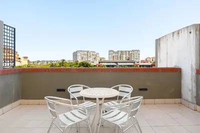 a table and chairs on the roof of a building at The Manhattan Apartments in Cape Town