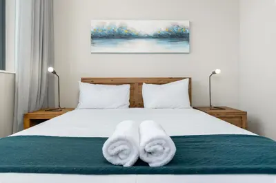 a bedroom with a bed with towels on it at The Axis Luxury Apartments in Cape Town