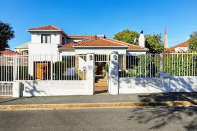 a white fence in front of a house at Villa Garda B&B in Cape Town