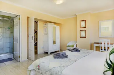 a bedroom with a large bed and a shower at Villa Garda B&B in Cape Town