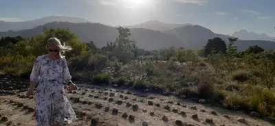 a woman in a dress walking on a hill at Gecko Cottage at Artemis in Franschhoek