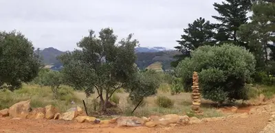 a stack of rocks in a field with trees at Gecko Cottage at Artemis in Franschhoek