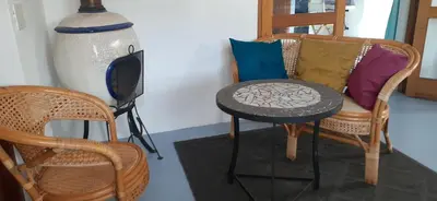 a room with two chairs and a table and a table at Gecko Cottage at Artemis in Franschhoek