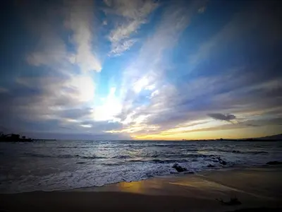 a sunset on the beach with the ocean at Bay-Side Apartment, Gordon's Bay in Gordonʼs Bay