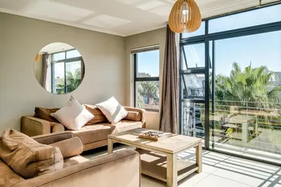 a living room with a couch and a table at Belina - Quayside Canal Front in Cape Town