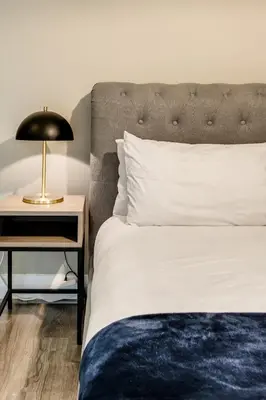 a bedroom with a bed and a nightstand with a lamp at Belina - Quayside Canal Front in Cape Town