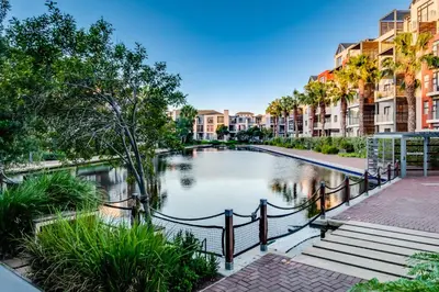 a pond in the middle of a city with buildings at Belina - Quayside Canal Front in Cape Town