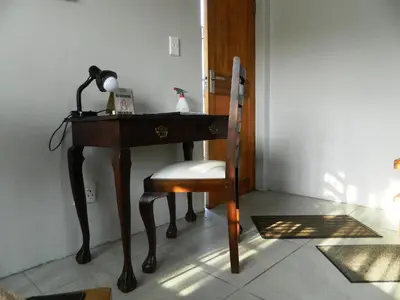 a desk with a chair and a lamp on it at Kunsvilla in Durbanville
