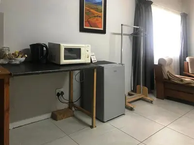 a microwave sitting on top of a counter with a refrigerator at Kunsvilla in Durbanville