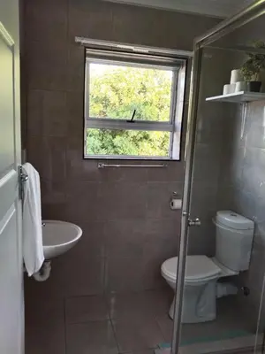 a bathroom with a sink and a toilet and a window at 24 Wrench Glenlilly Parow in Cape Town