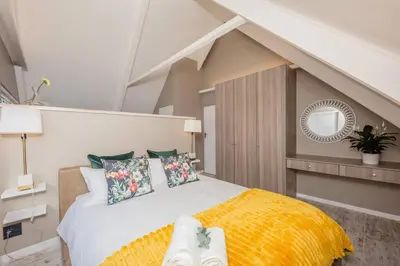 a bedroom with a large bed with a yellow blanket at House w Pool, Fireplace, Braai in Cape Town