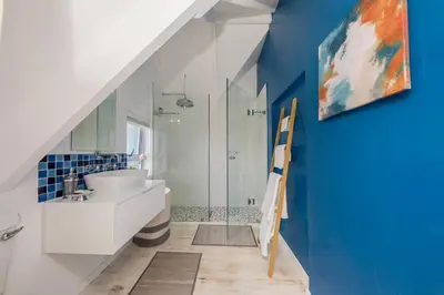 a bathroom with a white sink and a shower at House w Pool, Fireplace, Braai in Cape Town