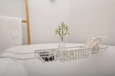 a white table with a shelf with a vase of flowers at House w Pool, Fireplace, Braai in Cape Town