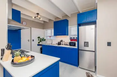 a blue kitchen with a bowl of fruit on a counter at House w Pool, Fireplace, Braai in Cape Town