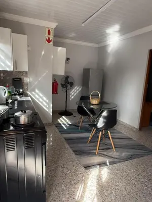 a kitchen with a table and chairs in a room at Finca Guest House in Cape Town