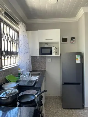 a kitchen with a counter top and a refrigerator at Finca Guest House in Cape Town
