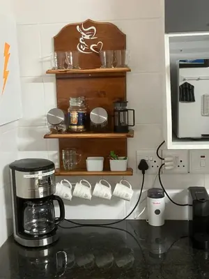 a kitchen counter with a coffee maker and a microwave at Strelitzia, spacious with a stunning view in Cape Town