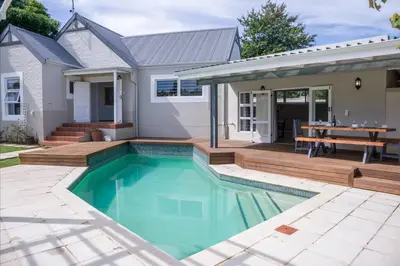 a house with a swimming pool and a wooden deck at A Touch of Country in Stellenbosch