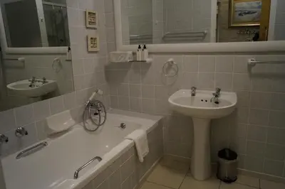 a bathroom with a sink and a tub and a sink and a toilet at Valentines Hermanus in Hermanus