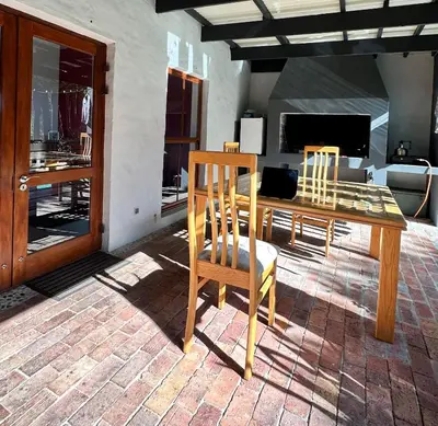 a wooden dining table and chairs in a living room at Hidden Gem on Onrus River in Hermanus