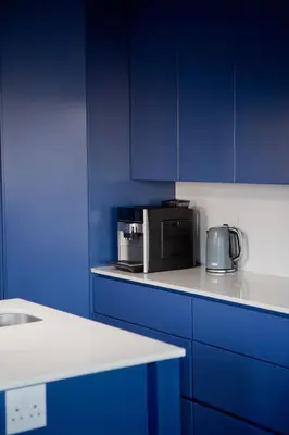 a blue kitchen with a microwave and blue cabinets at Villa Del Mar in Clareport