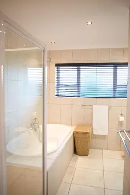 a white bathroom with a tub and a sink at Villa Del Mar in Clareport