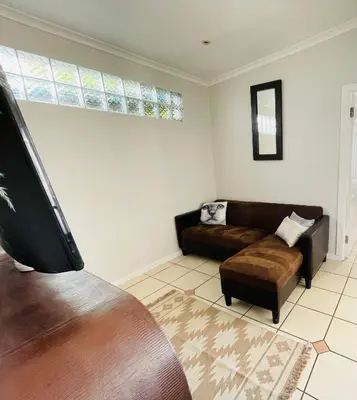 a living room with a couch and a chair at Sixth Avenue Residence Halaal Accommodation Cape Town in Cape Town