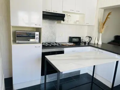 a kitchen with white appliances and a white counter top at Sixth Avenue Residence Halaal Accommodation Cape Town in Cape Town