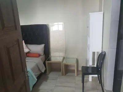 a small bedroom with a bed and a glass table at Mabel Guesthouse in Cape Town