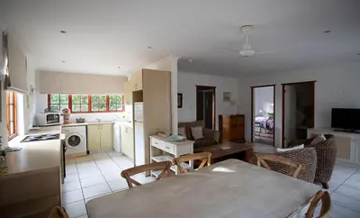 a kitchen and living room with a table and chairs at Wine Route 44 Guesthouse in Somerset West