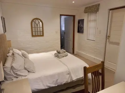a bedroom with a bed with a stuffed animal on it at Wine Route 44 Guesthouse in Somerset West