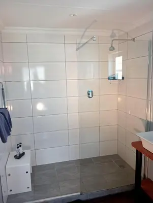 a shower with a glass door in a bathroom at Aloe Ocean Flatlet in Bettyʼs Bay