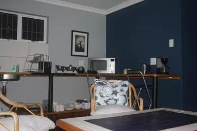 a room with a desk with a chair and a table at Aloe Ocean Flatlet in Bettyʼs Bay