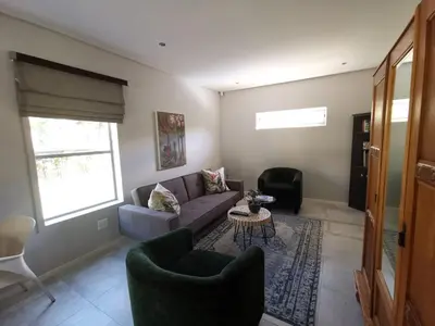a living room with a couch and a table at Oak Village in Stellenbosch
