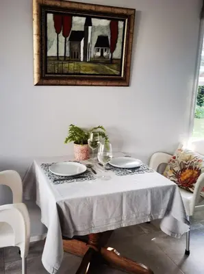 a table with a white table cloth and plates on it at Oak Village in Stellenbosch