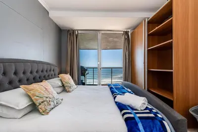 a bedroom with a bed with a view of the ocean at Horizon Bay 1502 in Cape Town