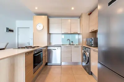 a kitchen with wooden cabinets and stainless steel appliances at Horizon Bay 1502 in Cape Town