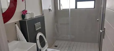 a bathroom with a toilet and a glass shower at LND GUEST HOUSE in Bloubergstrand