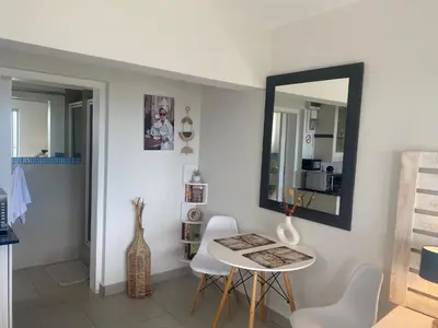 a table and chairs in a room with a mirror at Seaview Sunset Boutique Apartments Gordonsbay Solar powered in Cape Town