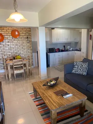 a living room with a couch and a table at Seaview Sunset Boutique Apartments Gordonsbay Solar powered in Cape Town