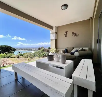 a living room with a table and a couch at Seaview Sunset Boutique Apartments Gordonsbay Solar powered in Cape Town