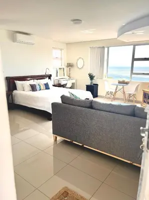 a living room with a bed and a couch in a room at Seaview Sunset Boutique Apartments Gordonsbay Solar powered in Cape Town