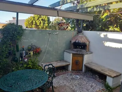 a patio with a table and a wood stove at Sol Y Sombra in Bettyʼs Bay
