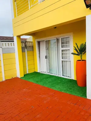 a yellow house with a potted plant in front of it at Mowetu Guest House in Cape Town