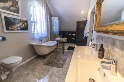 a bathroom with a tub and a toilet and a sink at Val de Vine in Stellenbosch