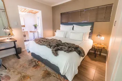 a bedroom with a large white bed with white pillows at Val de Vine in Stellenbosch