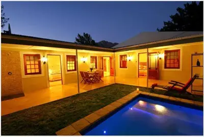 a house with a swimming pool in front of it at Cabriere Cottage in Franschhoek