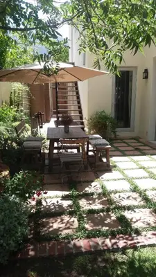 a picnic table and chairs under an umbrella on a patio at 3 on Roux in Franschhoek