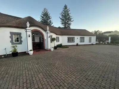 a white house with a brick driveway at The Sanctuary Guest House Estate in Cape Town
